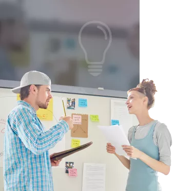 Auf diesem Bild sieht man zwei Personen die sich vor einem Whiteboard unterhalten.